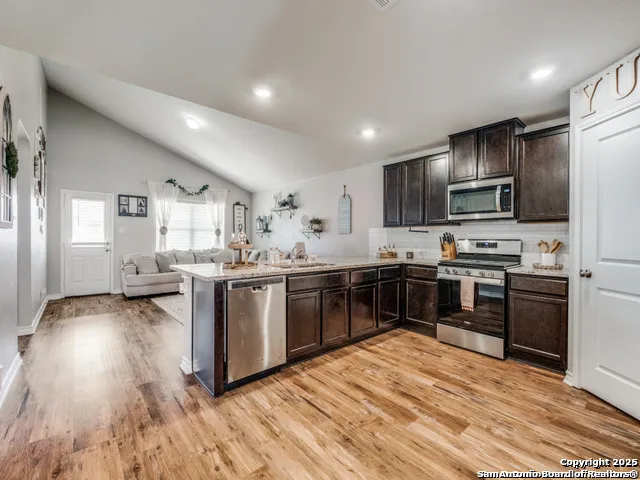 a kitchen with stove a sink and a refrigerator