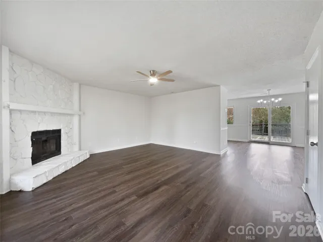 a view of a livingroom with wooden floor and a fireplace