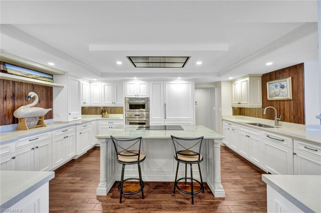 a kitchen with a dining table chairs refrigerator and cabinets