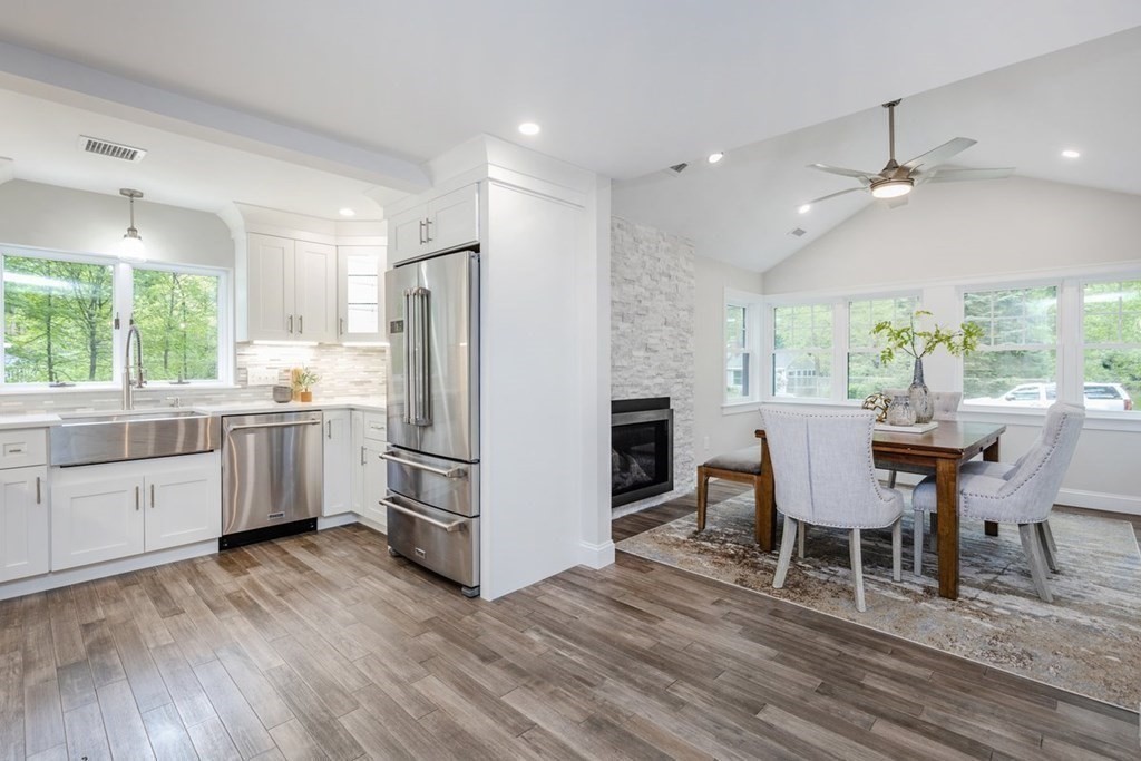 7 Elm Street North Reading, MA 01864 - Photo 5 of 42 a kitchen with stainless steel appliances granite countertop a stove a refrigerator a sink dishwasher a dining table and chairs with wooden floor