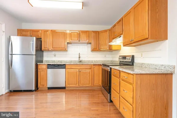 a kitchen with stainless steel appliances granite countertop a refrigerator sink and cabinets