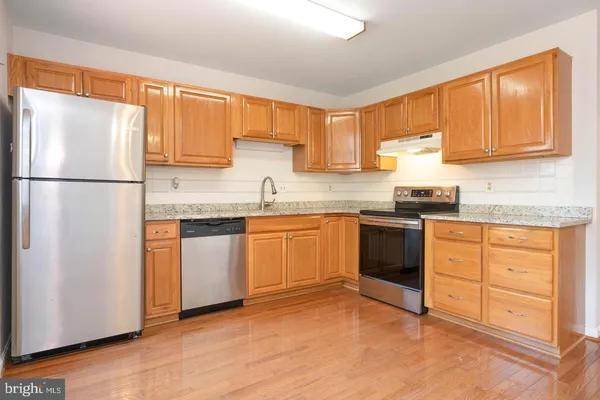 a kitchen with granite countertop cabinets stainless steel appliances and a sink