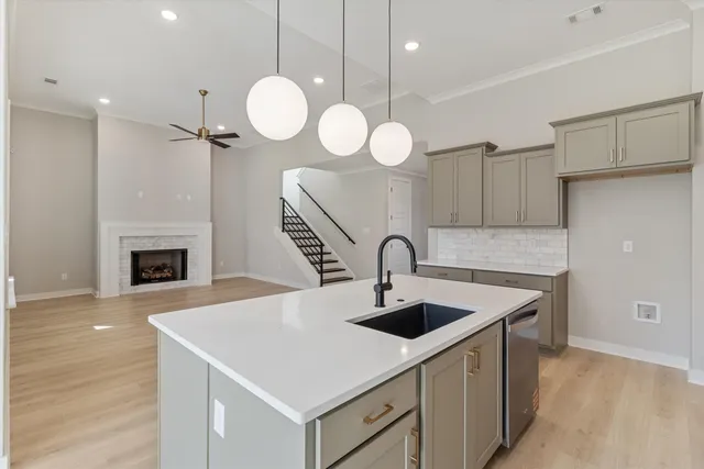 a kitchen with a sink a clock and cabinets