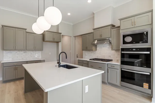 a kitchen with a sink a stove and oven