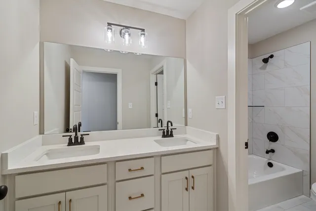 a bathroom with double sink and a mirror