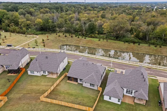 an aerial view of residential houses with outdoor space and lake view