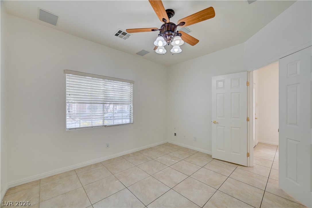 8918 Houston Ridge Avenue Las Vegas, NV 89178 - Photo 31 of 35 A quiet, well-lit bedroom features ample tile flooring and a ceiling fan.
