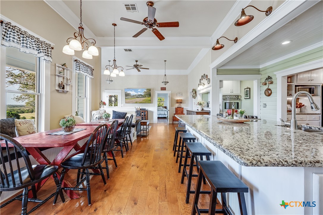13471 Cedar Valley Road Salado, TX 76571 - Photo 11 of 41 a view of a dining room and livingroom with furniture wooden floor a chandelier