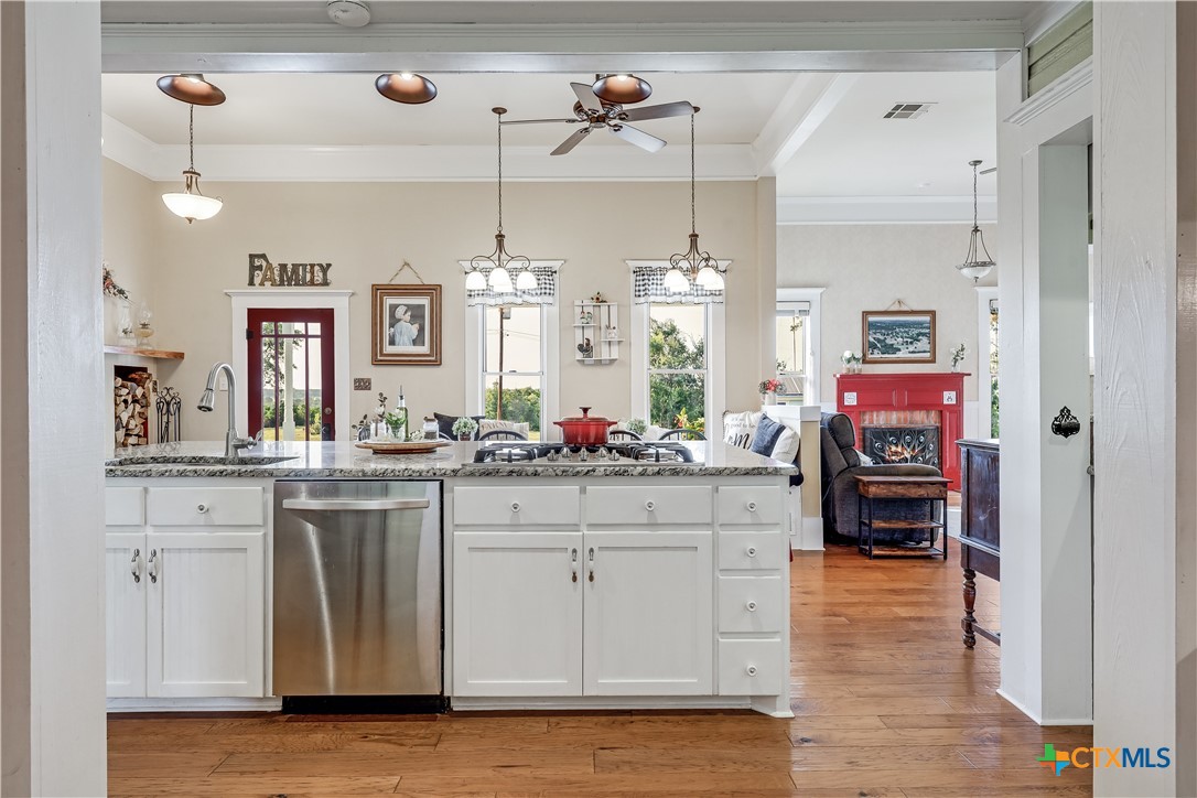 13471 Cedar Valley Road Salado, TX 76571 - Photo 14 of 41 a kitchen with granite countertop a white cabinets and chairs