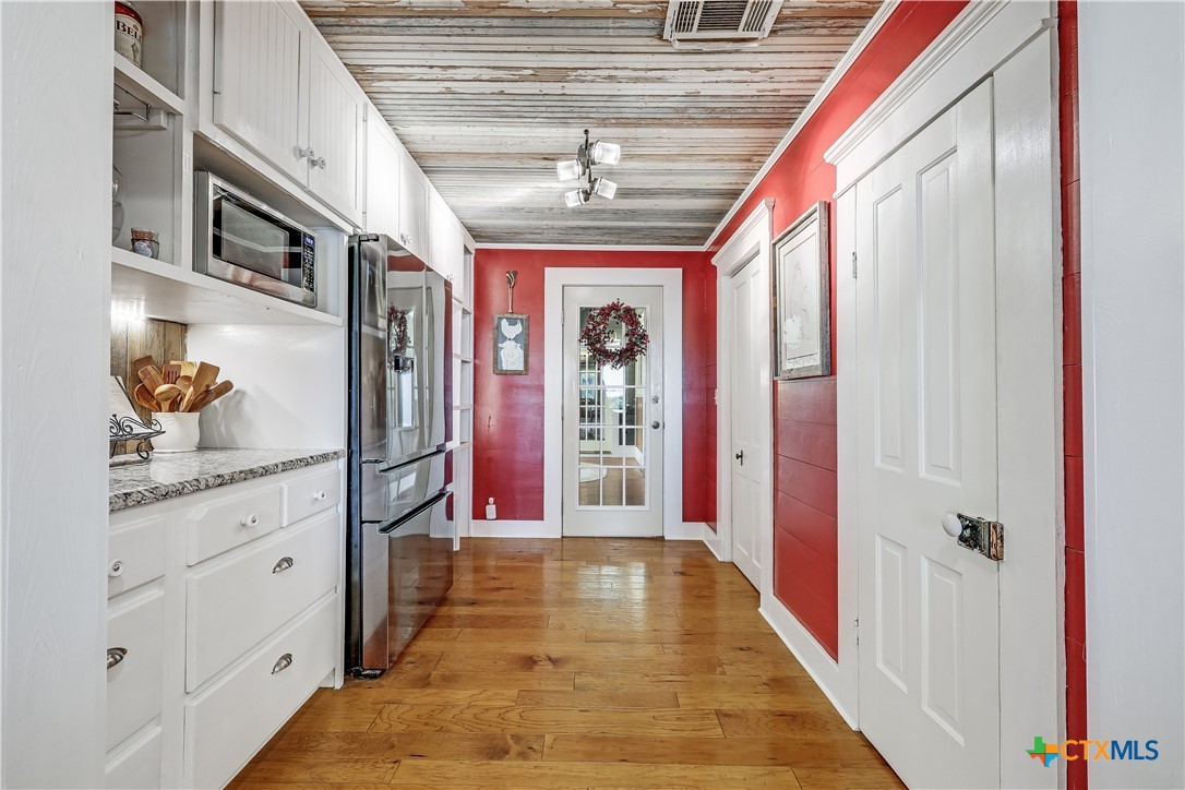 13471 Cedar Valley Road Salado, TX 76571 - Photo 20 of 41 a hallway with windows and chandelier