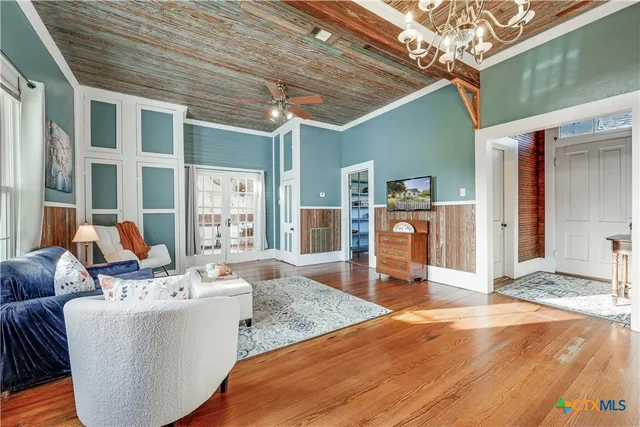 a dining room with furniture floor to ceiling window and wooden floor