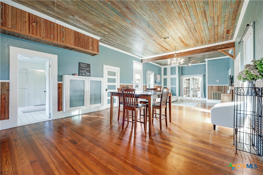 13471 Cedar Valley Road Salado, TX 76571 - Photo 26 of 41 a dining room with furniture floor to ceiling window and wooden floor