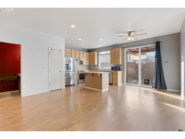 a view of a kitchen with a refrigerator a sink and a window