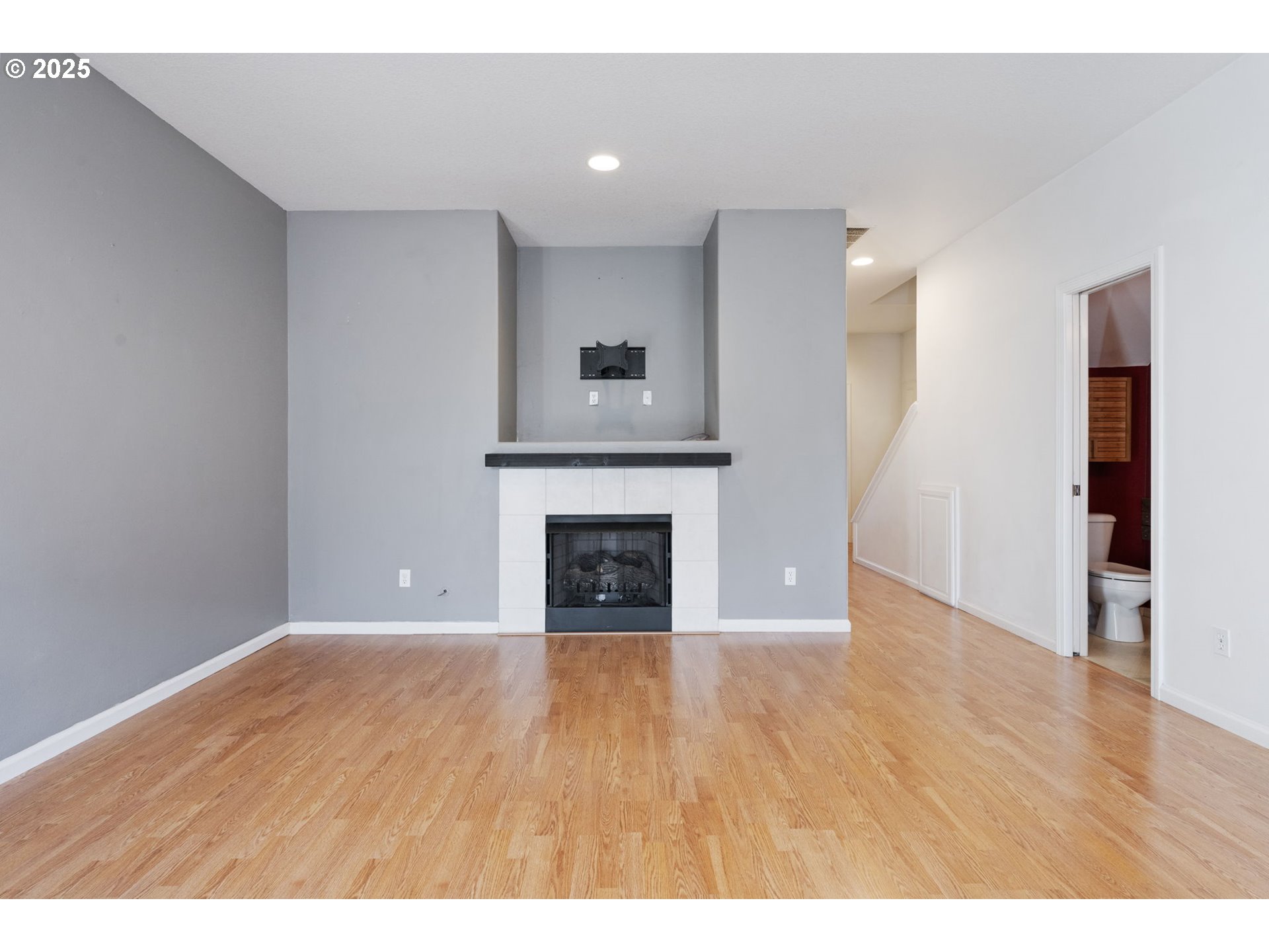 887 Southwest 198th Place Beaverton, OR 97003 - Photo 10 of 33 a view of an empty room with wooden floor fireplace and a window