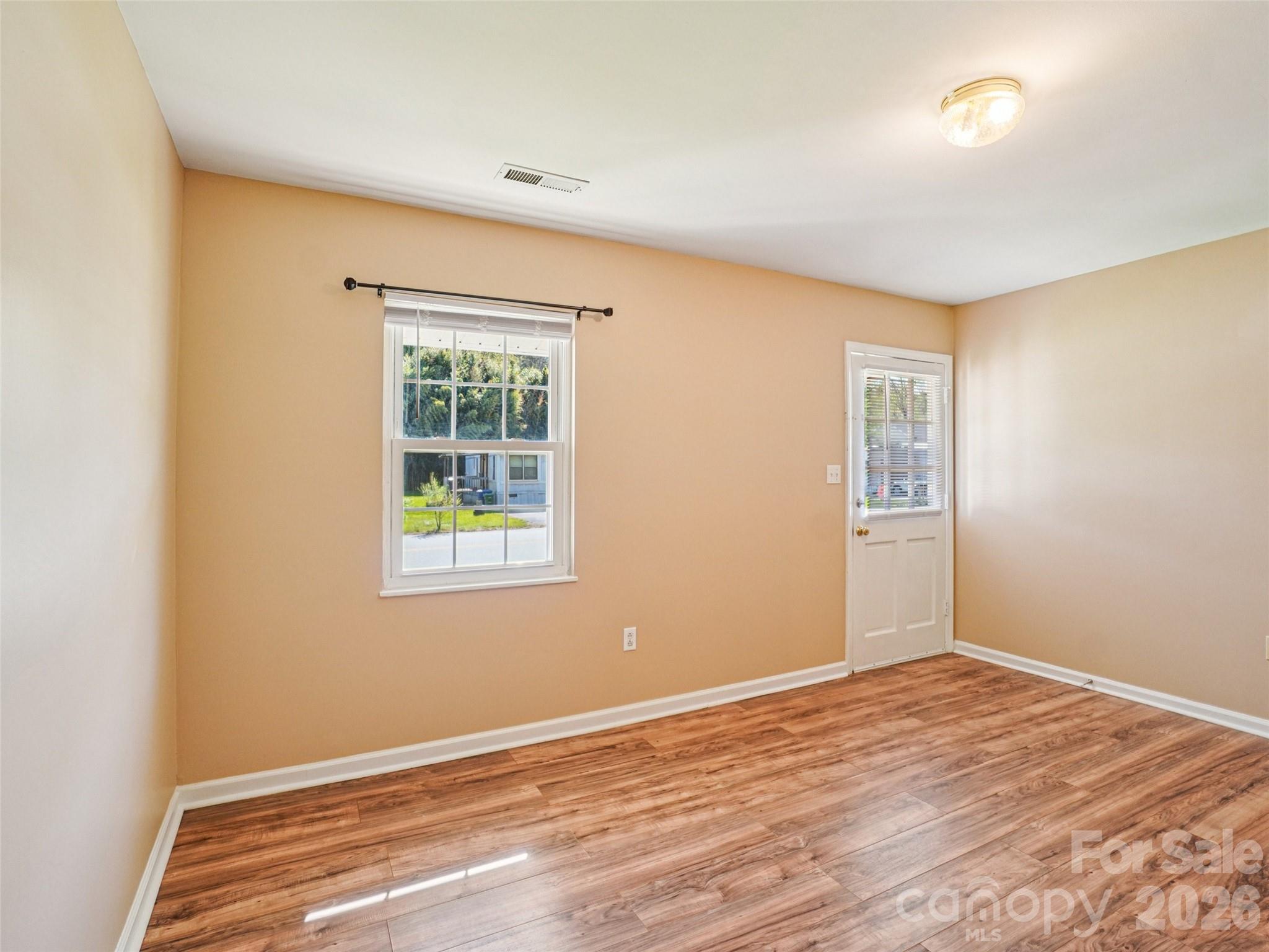 88 Lees Creek Road Asheville, NC 28806 - Photo 5 of 29 a view of an empty room with wooden floor and a window