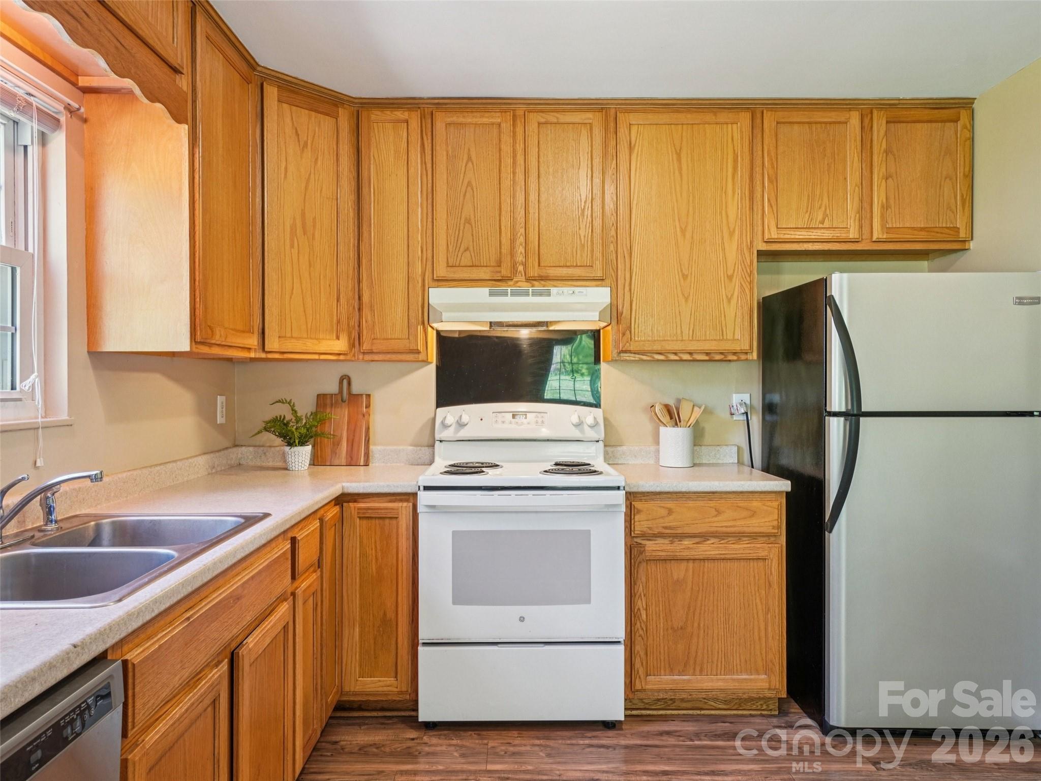 88 Lees Creek Road Asheville, NC 28806 - Photo 10 of 29 a kitchen with a sink a stove cabinets and a refrigerator