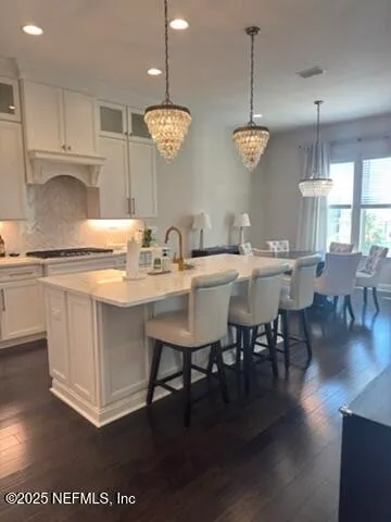 a kitchen with a dining table chairs and wooden floor