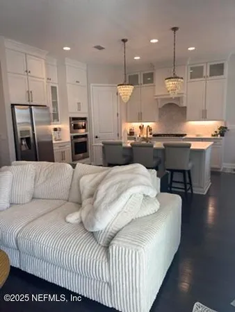a living room with furniture and kitchen view