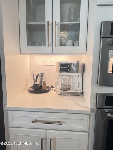 a close view of kitchen sink with granite countertop cabinets