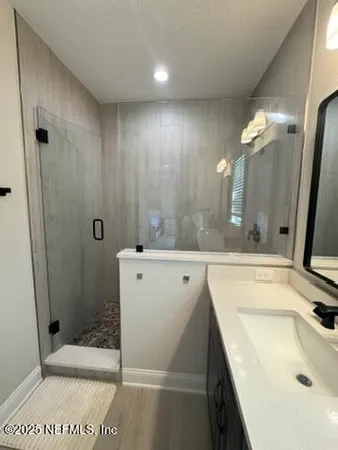 a bathroom with a sink a toilet and shower