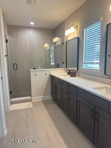 a spacious bathroom with a mirror a double vanity sink and shower