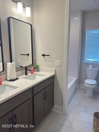 a bathroom with a sink a toilet and mirror