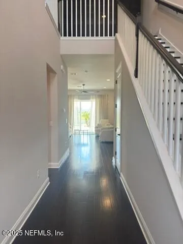 a view of a hallway with wooden floor and staircase