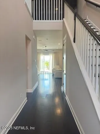 a view of a hallway with wooden floor and staircase