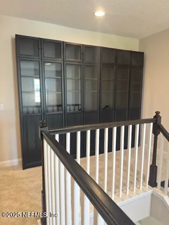 a view of staircase with railing and a window