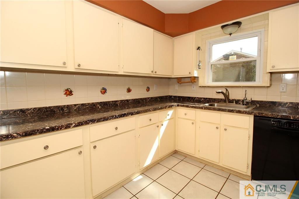 5203 Hana Road Edison, NJ 08817 - Photo 13 of 25 a kitchen with granite countertop white cabinets and a sink