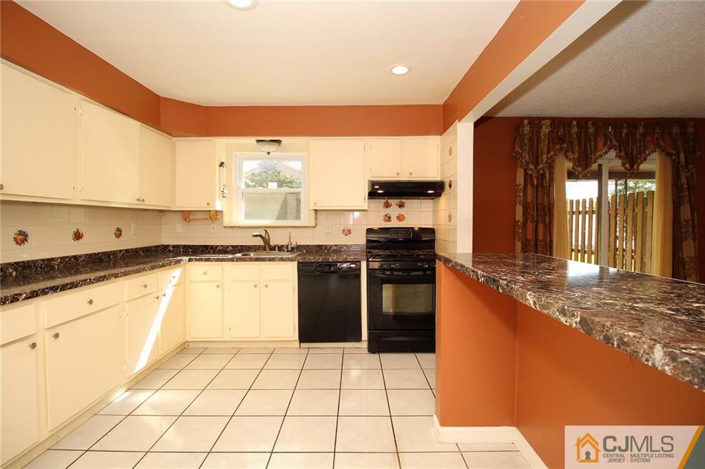 5203 Hana Road Edison, NJ 08817 - Photo 14 of 25 a kitchen with stainless steel appliances granite countertop a stove a sink and a microwave