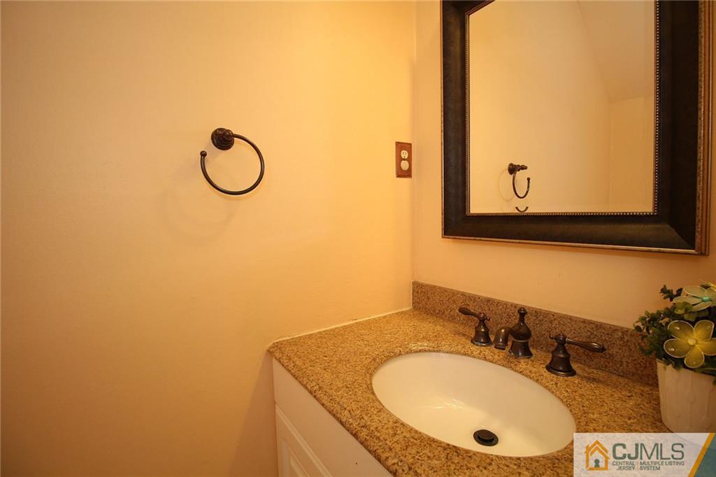 5203 Hana Road Edison, NJ 08817 - Photo 15 of 25 a bathroom with a granite countertop sink and a mirror