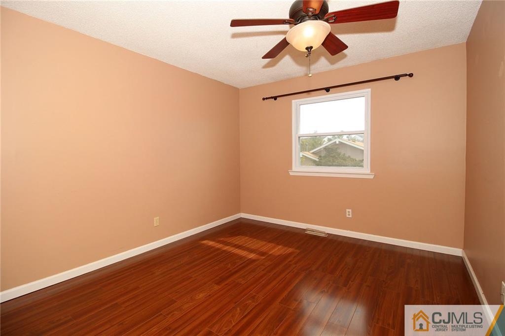 5203 Hana Road Edison, NJ 08817 - Photo 21 of 25 a view of an empty room with window and wooden floor