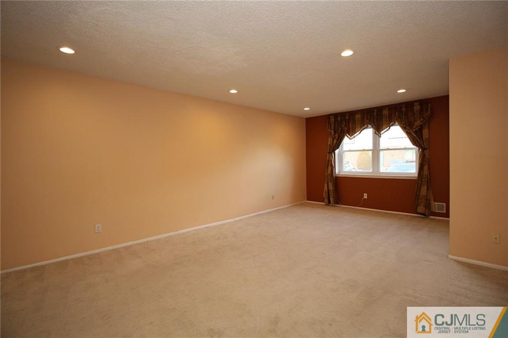 5203 Hana Road Edison, NJ 08817 - Photo 6 of 25 an empty room with a fireplace and windows