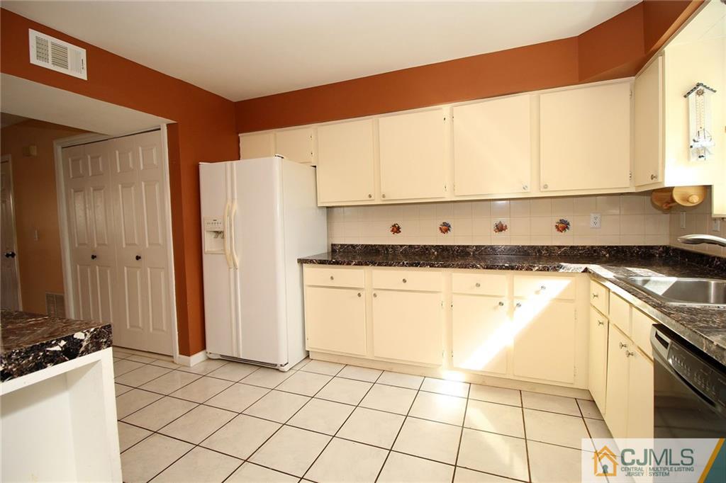 5203 Hana Road Edison, NJ 08817 - Photo 10 of 25 a kitchen with a sink a stove top oven and cabinets