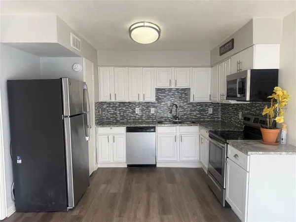 a kitchen with stainless steel appliances granite countertop a refrigerator sink and stove