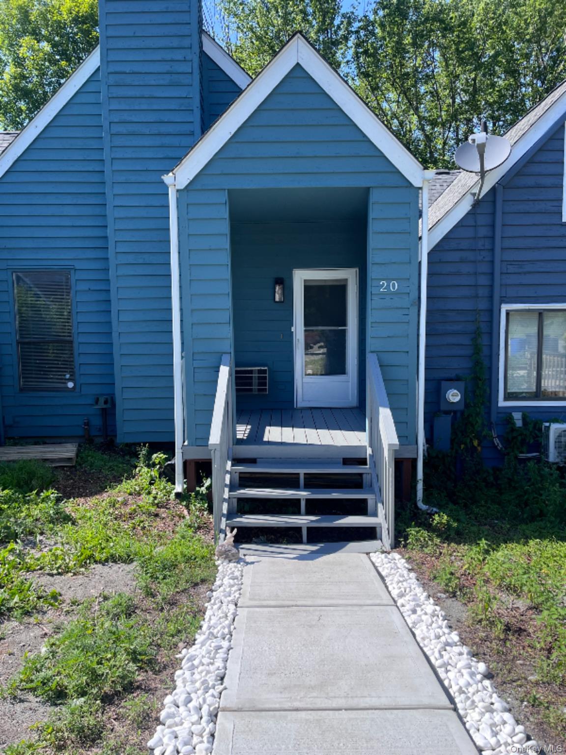 View of front of home with a chimney and a deck