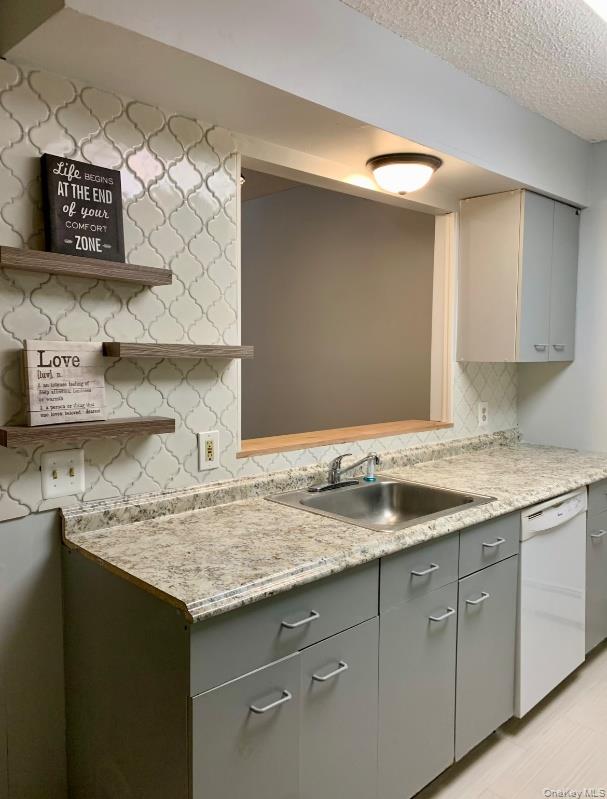 20 Fox Ridge Woodridge, NY 12789 - Photo 7 of 24 Kitchen featuring light countertops, gray cabinets, white dishwasher, backsplash, and open shelves
