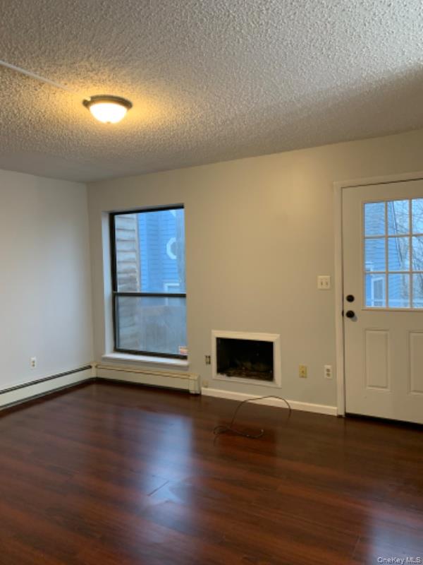 20 Fox Ridge Woodridge, NY 12789 - Photo 10 of 24 Unfurnished living room with dark wood finished floors and a textured ceiling