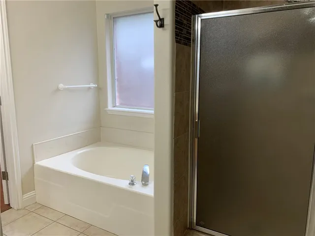 a white bath tub sitting next to a white sink and vanity