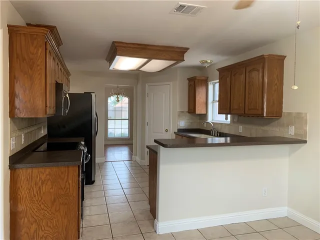 a kitchen with granite countertop a sink and a refrigerator