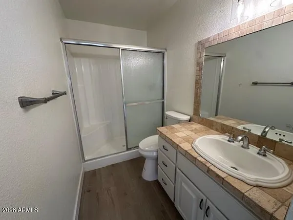 a bathroom with a granite countertop sink toilet and shower