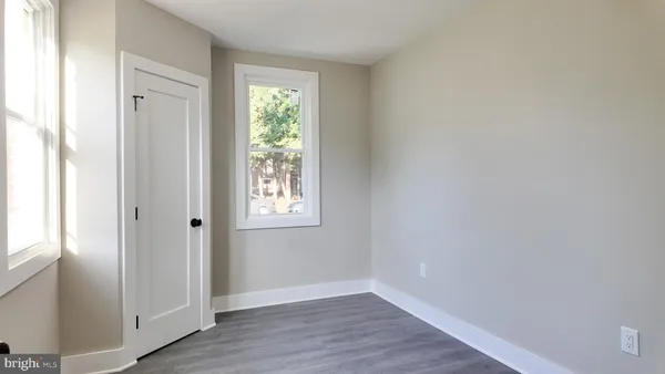 an empty room with wooden floor and a window