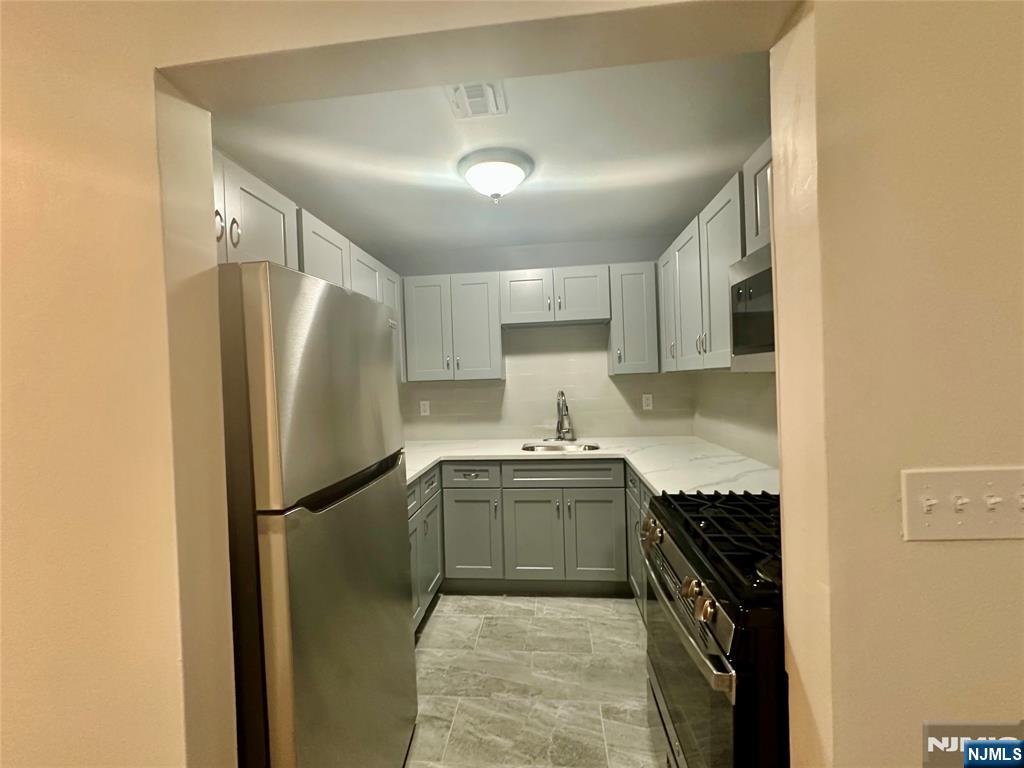46 Ferry Street, Unit 3F Newark, NJ 07105 - Photo 8 of 14 a kitchen with stainless steel appliances granite countertop a refrigerator a sink and a stove