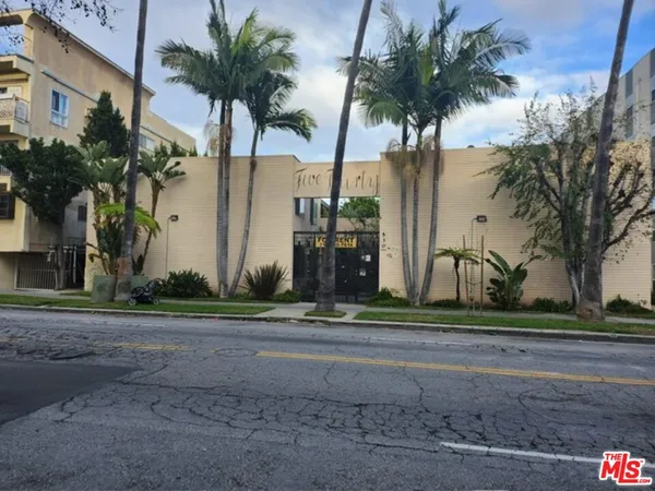 a couple of palm trees sitting in front of a house