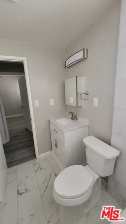 a white toilet sitting next to a bathroom sink