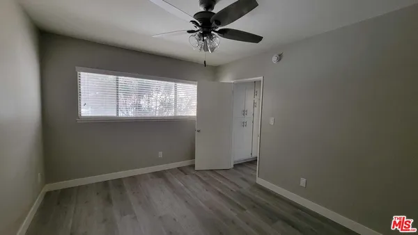 an empty room with a window and a fan