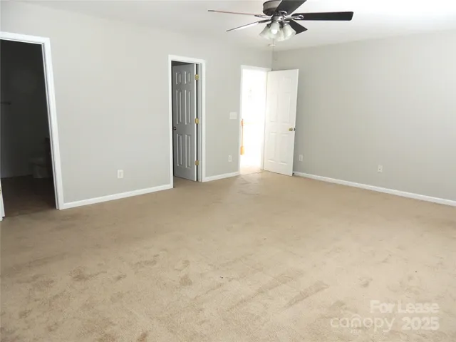 an empty room with a ceiling fan and a window