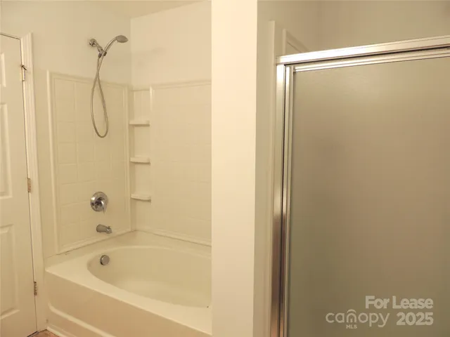 a bathroom with a shower and a bath tub