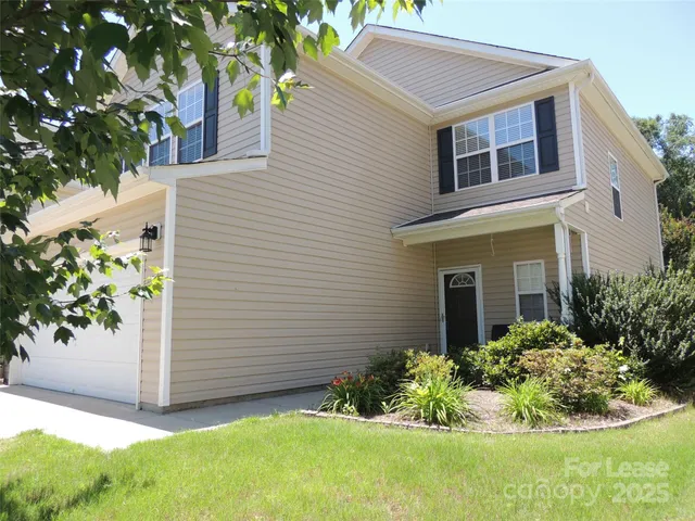 a view of a house with a yard and flower plants